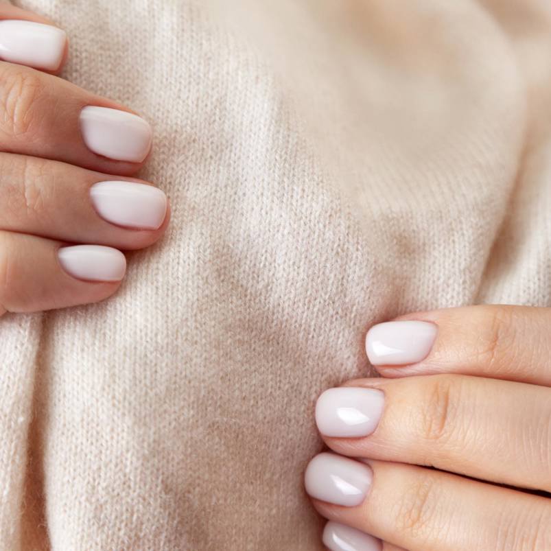 Person assessing the softness of a woollen material with their hands