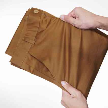 Person using hands to stretch fabric of trousers