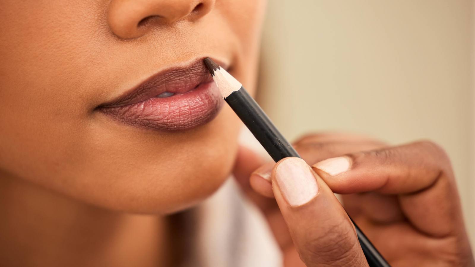 Person applying cosmetics to lips